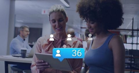 Colleagues Checking Tablet Notification in Modern Workspace
