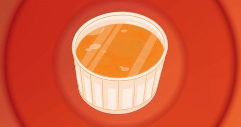 Vibrant ramekin filled with orange liquid on bold background