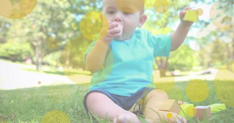 Happy baby engaged with toys in sunny park setting
