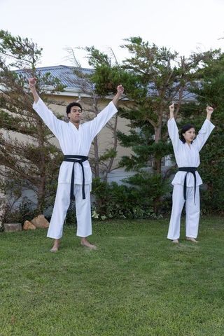 Diverse Partners Practicing Martial Arts Karate in Garden Setting