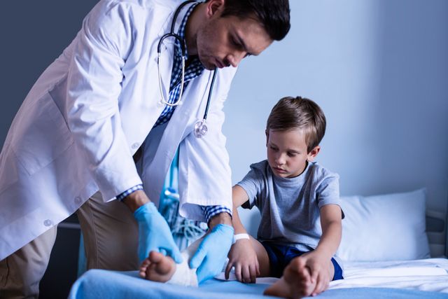 Doctor Examining Young Boy's Injured Leg in Hospital - Download Free Stock Photos Pikwizard.com