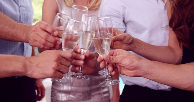 People clinking champagne glasses, enjoying social event, expressing joy. Perfect for promotional materials for party planning, event invitations, and festive themes.