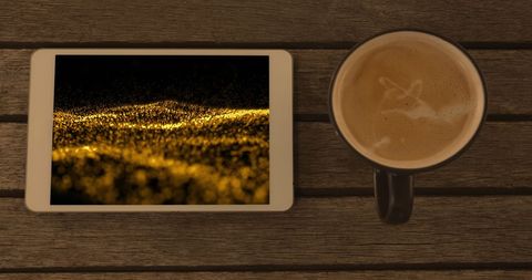 Smartphone with Abstract Gold Light Trails Display and Coffee Mug