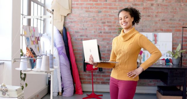 Confident Female Fashion Designer Working in Modern Studio with Laptop - Download Free Stock Images Pikwizard.com