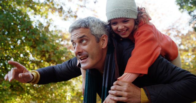 Joyful Father Piggybacking Young Daughter During Autumn Outdoor Adventure - Download Free Stock Images Pikwizard.com