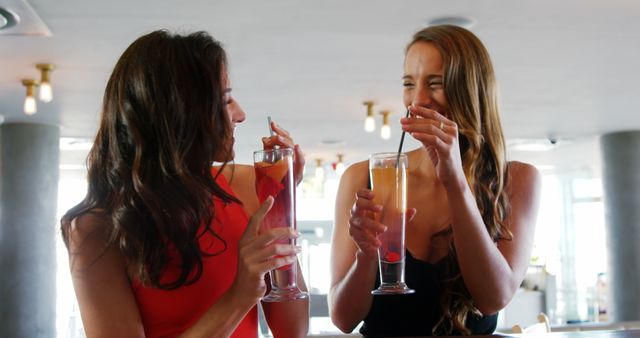 Young women toasting cocktail glasses in restaurant 