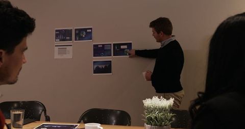 Businessman Presenting Charts in Office for Team Meeting Discussion