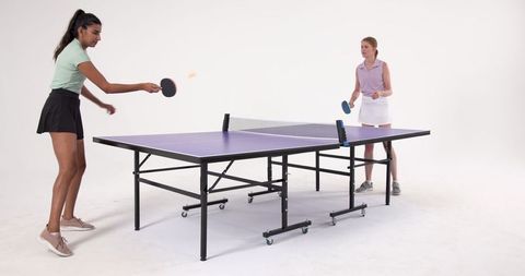 Diverse Women Enjoying Table Tennis in Minimalist Studio