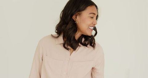 Smiling Woman in Casual Attire with Light Background