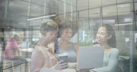 Three Women Collaborating in Modern Office Lounge with Laptop