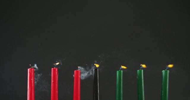 Candles are displayed burning with red, black, and green in an equal arrangement against a dark background. Perfect for celebrating Kwanzaa or African heritage events, this stock can be used for holiday card designs, cultural event promotions, or educational materials on traditional African practices. The colors represent unity, community, and tradition, making it a powerful visual for various informative or celebratory contexts.