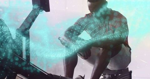 Athlete rowing in fitness studio with digital particle overlay