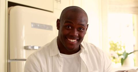 Smiling Man Enjoying Morning Coffee in Home Kitchen