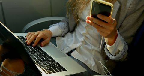 Professional Woman Multitasking with Laptop and Smartphone in Office - Download Free Stock Images Pikwizard.com