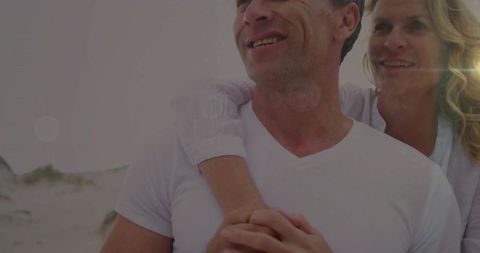 Smiling Mature Couple Embracing on Sandy Beach