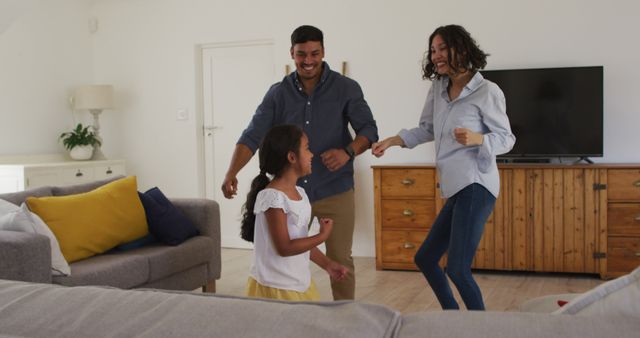 Happy hispanic family with daughter dancing having fun in living room. at home in isolation during quarantine lockdown.