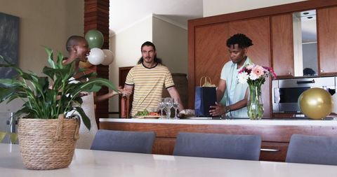 Friends Gathering in Modern Kitchen Enjoying Snacks and Drinks