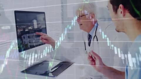 Senior Doctor Mentoring Junior with Candlestick Charts on Display