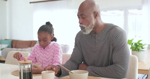 Man and girl sharing cozy morning breakfast in bright minimalist kitchen, bonding moment