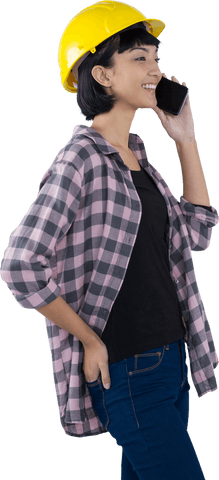 Smiling female architect in hard hat talking on mobile phone transparent png