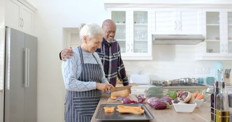 Senior Diverse Couple Joyfully Cooking in Modern Kitchen