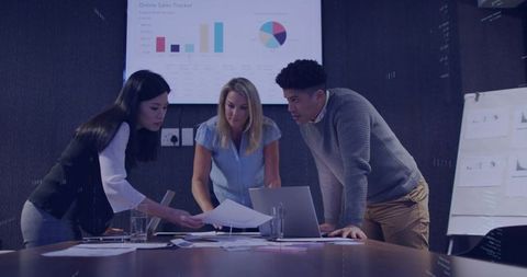 Diverse business team reviewing sales data and dashboards for strategic boardroom pitch