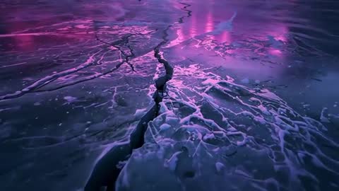 Camera zooming into frozen ice fissure at dusk revealing frost debris and pink purple glow