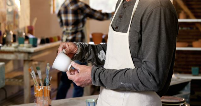 Close-Up of Artisan Glazing Pottery Man Working in Studio - Download Free Stock Images Pikwizard.com