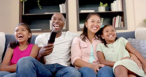 Happy Family Watching TV Together in Living Room