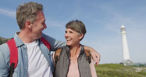 Happy Senior Couple Walking by Lighthouse, Enjoying Outdoor Adventure