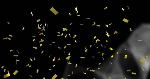 Falling gold confetti glinting on dark backdrop with rising gray smoke plume