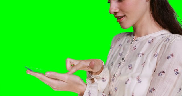 Woman pretending to hold digital tablet against green screen