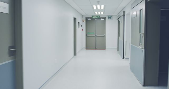 A clean hospital corridor appears empty, with an exit sign visible. The sterile environment suggests a focus on hygiene and organization in healthcare settings.