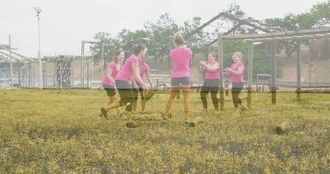 Women team building workout on outdoor obstacle course