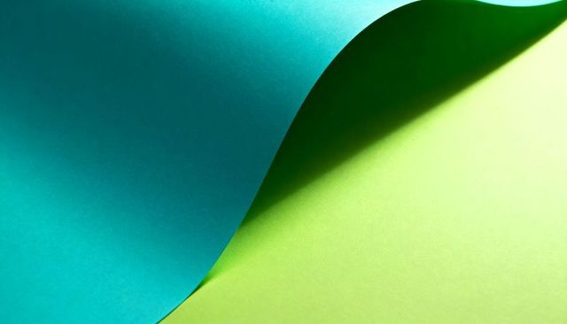 Curling teal paper revealing lime green surface casting soft shadow abstract minimal