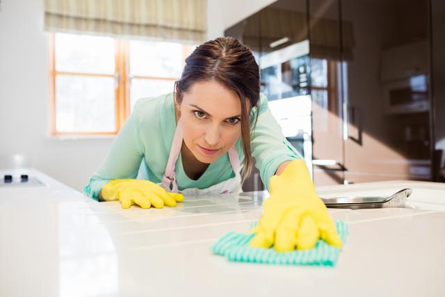 Woman Cleaning Kitchen Counter with Determination - Download Free Stock Photos Pikwizard.com