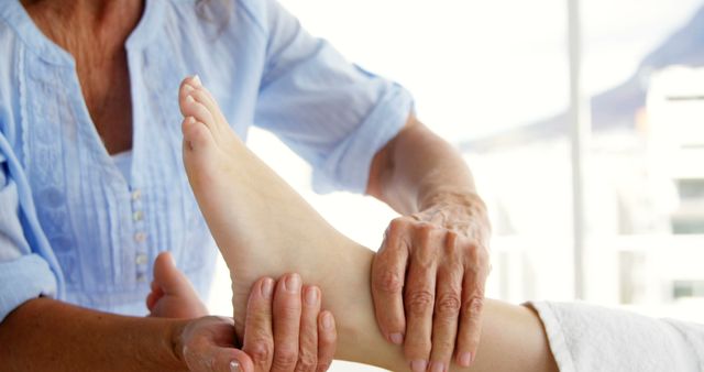 Therapist performing expert reflexology on a female client's foot. Perfect for wellness and spa websites, health and therapy brochures, relaxation and holistic health content.