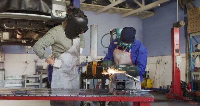 Mechanics Welding Metal in Auto Repair Shop Workshop - Download Free Stock Images Pikwizard.com