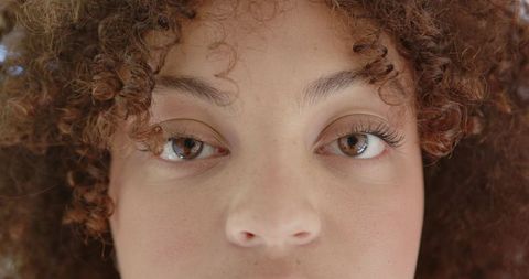 Close-Up Portrait of Woman with Freckled Skin and Curly Hair