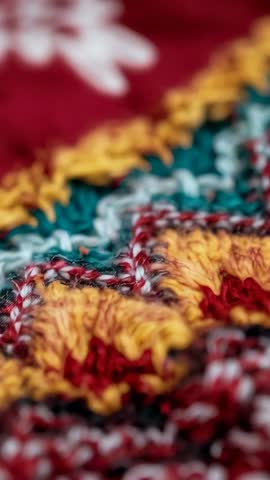 Vertical macro video zooming colorful handmade textile highlighting yarn loops and texture