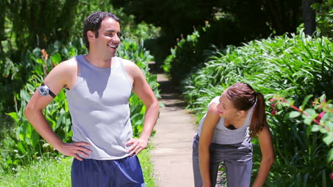 Active Couple Enjoys Jogging in Park Trail