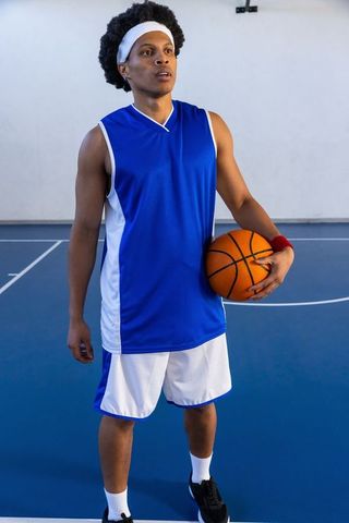 Unified Athletic Focus of Basketball Player Holding Ball on Court