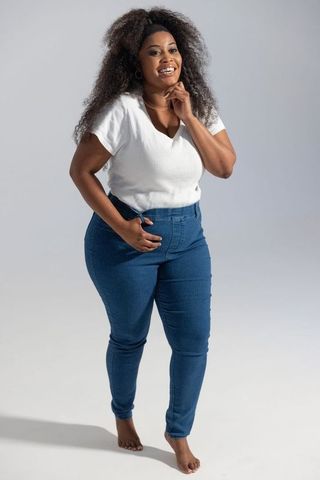 Confident african american woman modeling casual blue jeans and white ribbed v-neck top