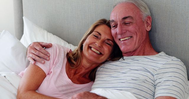 Senior couple embracing on bed in bed room
