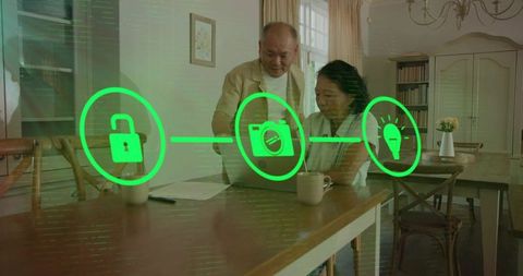 Senior couple exploring smart home controls on laptop in cozy wooden dining room