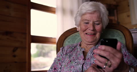 Senior Woman Enjoys Using Smartphone at Home