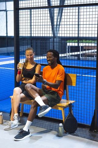 Friends Relaxing on Padel Court Bench in Sportswear