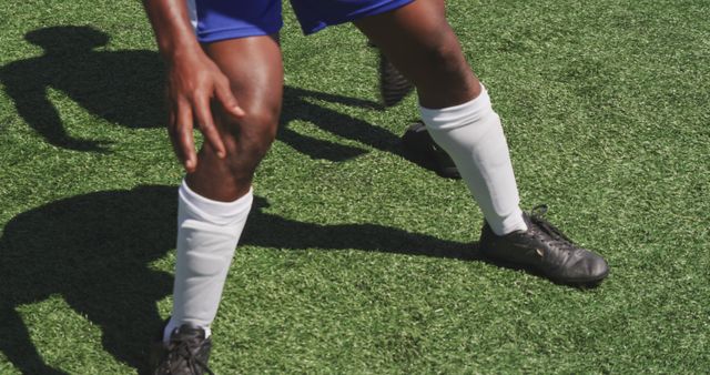 Athlete in Blue Soccer Kit Stretching on Field - Download Free Stock Images Pikwizard.com