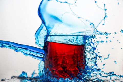 Vibrant red water in falling blue splash