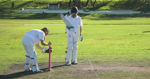 Teenage Female Cricketers Preparing for Match on Sunny Day